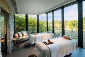 two beds in a room with large windows at Hilton Yala Resort in Yala