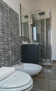 a bathroom with a toilet and a sink and mirror at Hotel Ogliastra in Lotzorai