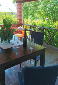 drewniany stół z 2 kieliszkami do wina na patio w obiekcie In the Green w mieście Lopatinec