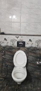 een badkamer met een wit toilet in een kamer bij RRM Stays - Jambu Savari Dinne in Bangalore