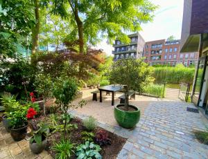 un jardín con una mesa de picnic y algunas plantas en The Green Tunnel en Ámsterdam