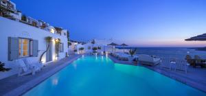 una piscina con vistas al océano por la noche en Smy Mykonos Suites & Villas - ex Greco Philia, en Playa de Elia