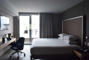 a hotel room with a bed and a desk and a window at Ramada by Wyndham Mexico City Santa Fe in Mexico City