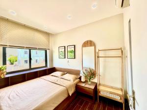 sypialnia z łóżkiem i lustrem w obiekcie Dk House Hue w mieście Hue