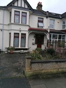 a white house with a red door at Double Room available- London Seven Kings Seven Kings Train Station in Seven Kings