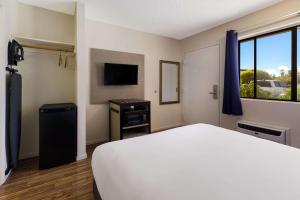 a hotel room with a bed and a television at Rodeway Inn Livermore in Livermore