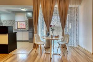 a dining room with a table and chairs and a kitchen at Refugiu liniștit în Băneasa in Bucharest