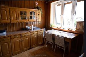 una cucina con armadi in legno e tavolo con sedie di Wiejska Sielanka 