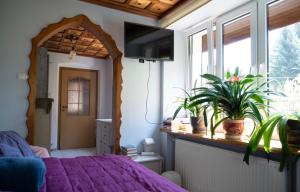 una camera con letto viola e finestra di Wiejska Sielanka 