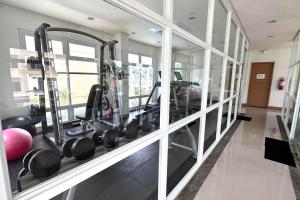 a gym with a bunch of equipment in a room at 2 Bedroom and 1 Bedroom Apartments with Private Pool and Gym in Puerto Princesa City