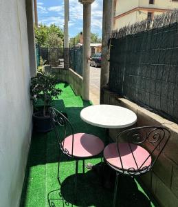2 sillas y una mesa y una mesa y sillas en un patio en CANNONHOUSE La Pavoncella Rosa en Bari Sardo