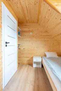 Habitación pequeña con cama y techo de madera. en Siedlisko Jantar Resort&Spa en Jantar