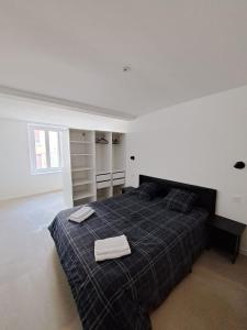 1 dormitorio con 1 cama con 2 toallas en T2 Autonome, centre ville proche Cathédrale en Toul