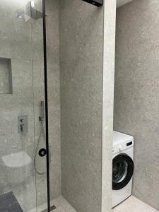 een badkamer met een wasmachine en een wasmachine bij Lindi's Apartment 8/1 in Tirana