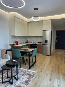 een keuken en een woonkamer met een tafel en een koelkast bij Lindi's Apartment 8/1 in Tirana