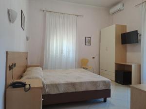 ジェンツァーノ・ディ・ローマにあるHotel Villa Robiniaのベッドルーム(ベッド1台、テレビ付)