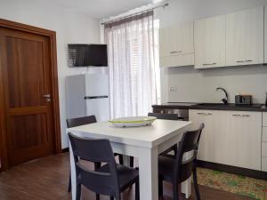 a kitchen with a white table with chairs and a white refrigerator at La Torre in Santo Stefano di Camastra
