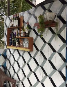 a wall with a shelf with bottles on it at Naca Homestay in Manado