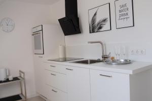 a white kitchen with a sink and a microwave at Ferienwohnung Anni in Schneverdingen