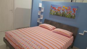 a bedroom with a bed with a painting on the wall at NICUZZA in Termini Imerese