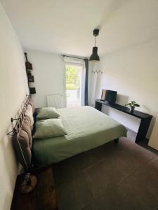 um quarto com uma cama e uma janela em Agréable Loft aux portes de bordeaux em Artigues-près-Bordeaux