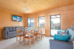una sala da pranzo con tavolo, sedie e divano di SIEDLISKO JANTAR Resort&Spa a Jantar