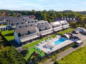 央塔的住宿－SIEDLISKO JANTAR Resort&Spa，享有带游泳池的大房子的空中景致