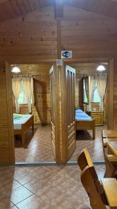 Kompleksi Turistik Leonardo في شينجين: غرفة بسريرين في كابينة خشبية