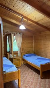 two beds in a room with wooden walls at Kompleksi Turistik Leonardo in Shëngjin