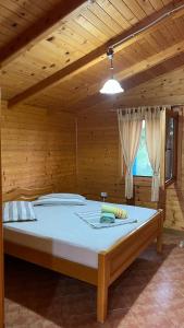 ein Schlafzimmer mit einem großen Bett in einem Holzzimmer in der Unterkunft Kompleksi Turistik Leonardo in Shëngjin
