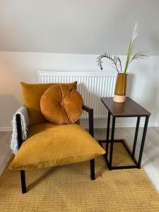 une chaise avec un oreiller et une table avec une plante dans l'établissement Schönes Loft in Bergrheinfeld 90 qm max 5 Personen, à Bergrheinfeld