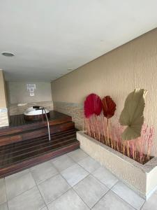 a lobby with three red flowers on the wall at Vista Espetacular Porto Real suítes in Mangaratiba +49 photos