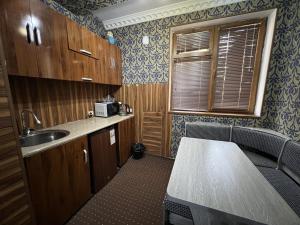 eine Küche mit einer Spüle und einer Arbeitsplatte in der Unterkunft Status House in Fargʻona
