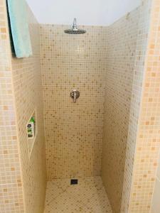 een badkamer met een douche en gele betegelde muren bij Porto Antigo 2 Beach Club in Santa Maria