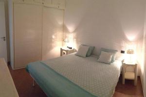 1 dormitorio con 1 cama con 2 lámparas en Porto Antigo 2 Beach Club, en Santa Maria