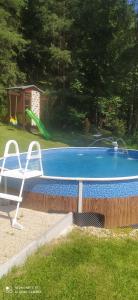 a swimming pool with a chair and a white chair next to it at Chata v Lískách in Lísky
