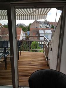 a wooden deck with a chair on a balcony at Studios KRY in Strasbourg +3 photos