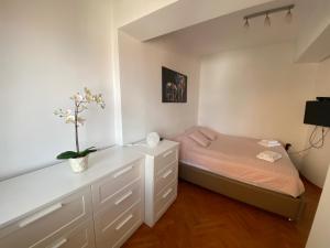 - une petite chambre avec un lit et une commode dans l'établissement Porta Ruzveltova Apartment, à Skopje