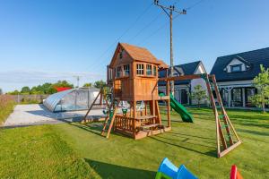 a playground with a tree house and a slide at Osada Jantar 3 in Jantar