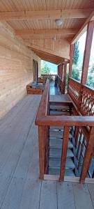 a large wooden deck with benches in a cabin at Guest House Shina in Omalo