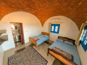 an attic room with two beds and a mirror at Aladdin Camp in Nuweiba