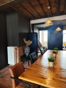 a dining room with a long wooden table and chairs at Rooftop apartment with 60m terrace overlooking the cathedral in Antwerp