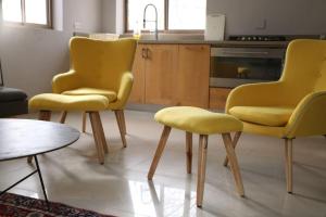 una cucina con due sedie gialle e un tavolo di Lahav Suite a Kefar Daniyyel