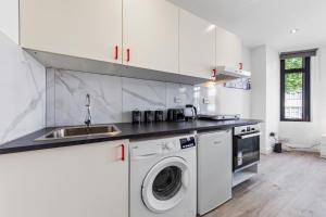 een keuken met een wastafel en een wasmachine bij Comfy 1BDR - 30mins to CENTRAL LDN - Parking in The Hyde