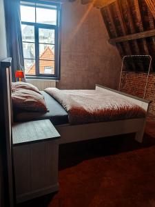 a small bedroom with a bed and a window at Rooftop apartment with 60m terrace overlooking the cathedral in Antwerp