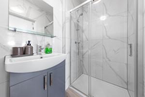 a white bathroom with a sink and a shower at Comfy 1BDR - 30mins to CENTRAL LDN - Parking in The Hyde