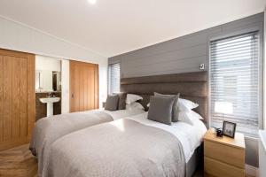 Un dormitorio con dos camas y una ventana. en Shropshire Lodges - Romantic Luxury Hot Tub Breaks, en Bridgnorth