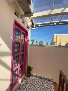 eine rosa Tür an der Seite eines Hauses in der Unterkunft Et Malio Stay & Travel in Sentool