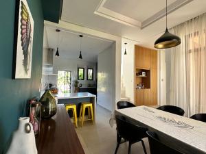 eine Küche und ein Esszimmer mit einem Tisch und Stühlen in der Unterkunft Jolie villa Front de Golf in Marrakesch