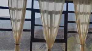 two curtains in a window with a view at Tizi Maison d'Hôtes in Telouet